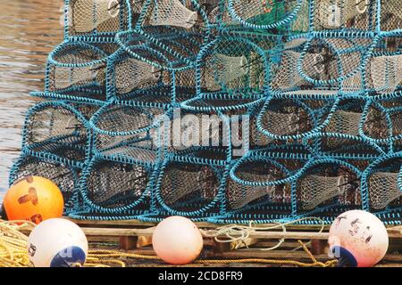 a close up view of fishing, lobster, pots stacked on a pallet on the pier with ropes and bouys Stock Photo