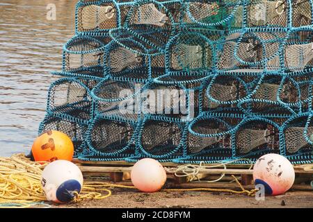 a close up view of fishing, lobster, pots stacked on a pallet on the pier with ropes and bouys Stock Photo