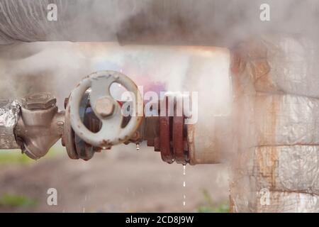 Leakage of hot water and steam from the heat pipeline. Water leakage in the pipe Stock Photo