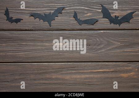 Happy Halloween holiday background with craft paper in the form of bats on wooden table. Stock Photo