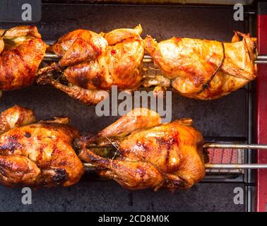 Close up photo of roasted chickens on spits in a grill Stock Photo