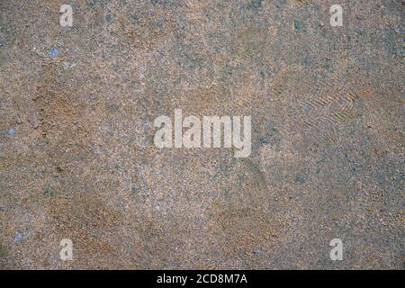 Sand and dirt on road surface. Dirty road texture. Grainy sand with tier marks. Grey brown asphalt with dust. Grit texture detailed backdrop for rusti Stock Photo