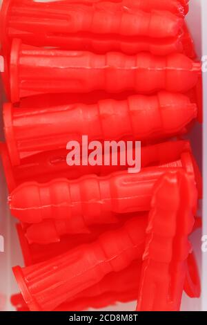Red plastic dowels for self-tapping screws close-up. Stock Photo