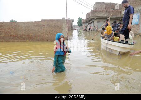 Hyderabad, Pakistan. 27th Aug, 2020. A girl stand in water while a rescue boat carrying families to a safe place (Photo by Jan Ali Laghari/Pacific Press) Credit: Pacific Press Media Production Corp./Alamy Live News Stock Photo