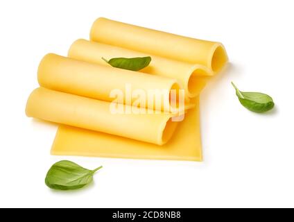 Cheese slices isolated on white background. Pieces of cheese with basil leaves. Stock Photo