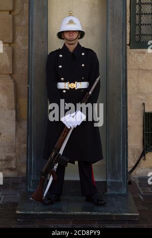A guard holding a rifle with bayonet at the entrance of President's Palace in Valletta, Malta Stock Photo