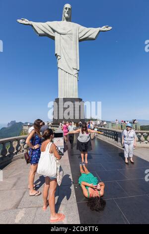 Brazil, state of Rio de Janeiro, city of Rio de Janeiro, hill of Corcovado, Carioca landscapes between the mountain and the sea classified World Heritage of UNESCO, tourists taking a picture in front of Christ the Redeemer Statue Stock Photo