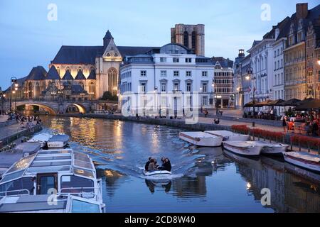 Belgium, East Flanders, Ghent, Night navigation on the Lys river along the Graslei (Herbs Quay) and the Saint Michel church in the background Stock Photo