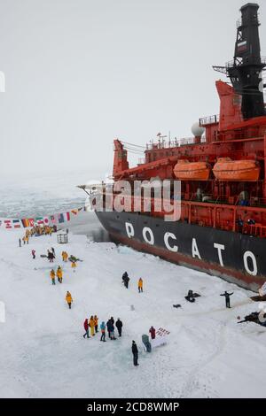 Russia, High Arctic, Geographic North Pole. 90 degrees north with 50 Years of Victory Russian icebreaker. Aerial view of adventure tourists at Pole. Stock Photo