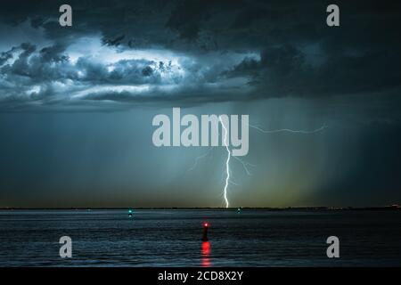 Dramatic landscape image of a lightning bolt striking down from a high based thunderstorm Stock Photo
