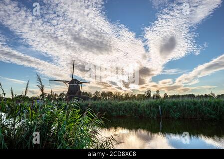 Spacious skies: altocumulus cloud sheet over a windmill in a classic dutch landscape Stock Photo
