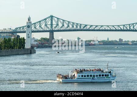 Canada, Quebec, Montreal, a river shuttle on the St. Lawrence River, the Clock Tower and the Jacques Cartier Bridge in the background Stock Photo