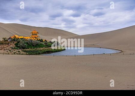 Singing Sand Dunes, illuminated pavilion and Yueyaquan / Yueya Lake / Crescent Moon Lake, oasis near Dunhuang in Gansu Province, China Stock Photo