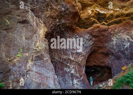 Spain, Canary Islands, La Palma, tourist on a hiking path under a vault volcanic rocks at seaside Stock Photo