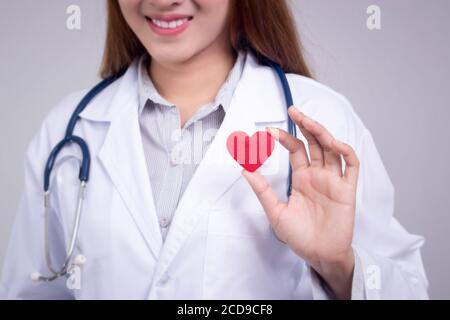 Healthy concept : Young Asian doctor with red heart in hand , anonymous face Stock Photo