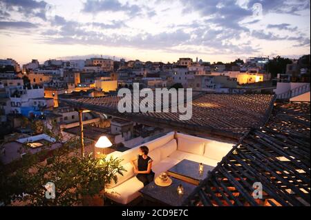 Morocco, Tangier Tetouan region, Tangier, Dar Nour hotel, woman on the terrace of Dar Nour guest house, overlooking the Kasbah, at nightfall Stock Photo