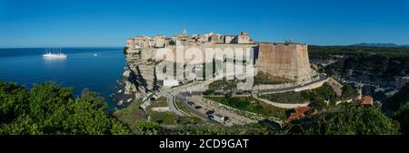 France, Corse du Sud, Bonifacio, panorama of the upper town located in the citadel and built on limestone cliffs overlooking the sea where is anchored the sailboat 4 mats of the Mediterranean club in the foreground chapel Saint Roch Stock Photo