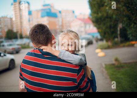 Rear view of father walking back to school with his little daughter. Stock Photo