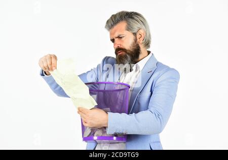 Recover document. Destroy evidence. Rummaging in trash. Recover files after deletion. Businessman hold trash can. Man look for lost document in paper bin. Office worker digging in garbage bin. Stock Photo