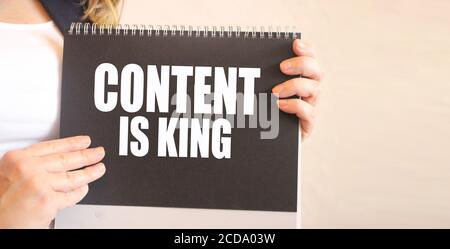 CONTENT IS KING words on black notepad in businesswoman hands. business concept Stock Photo