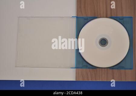 DVD with acrylic cover on white, blue and wood background Stock Photo