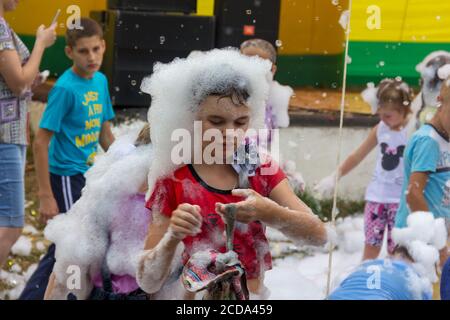 Kamennomostsky, Russia - September 1, 2018: Happy children having fun at a foam party at a holiday town day Kamennomostsky in an autumn park Stock Photo