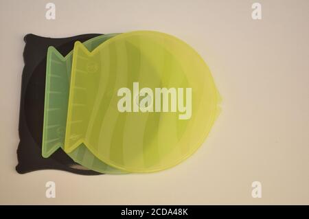 Plastic cd and dvd covers in fish format in different colors on white background with top view negative Stock Photo