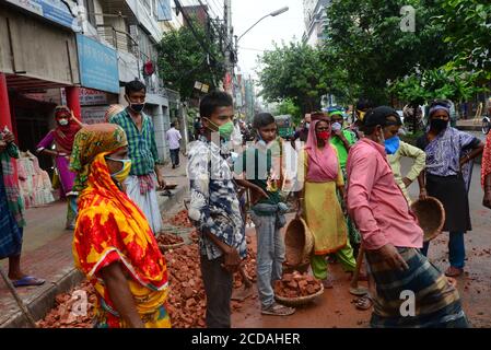 Daily Labors wearing facemask works at a road construction site during the coronavirus outbreak in Dhaka, Bangladesh, on June 13, 2020 Stock Photo