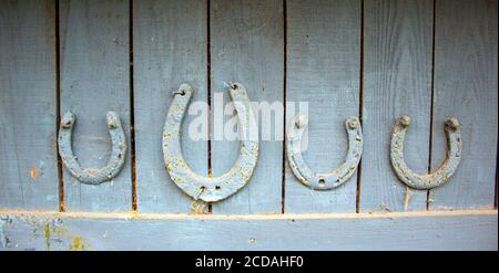 Set of old rusty horseshoes on a wooden background. Horseshoe is a symbol of good luck. Stock Photo