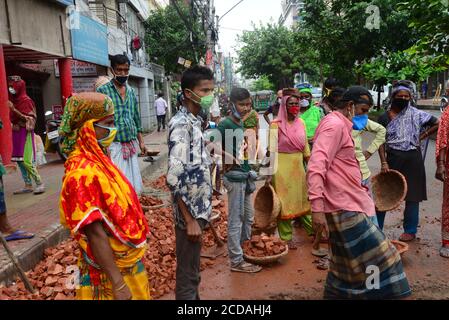 Daily Labors wearing facemask works at a road construction site during the coronavirus outbreak in Dhaka, Bangladesh, on June 13, 2020 Stock Photo