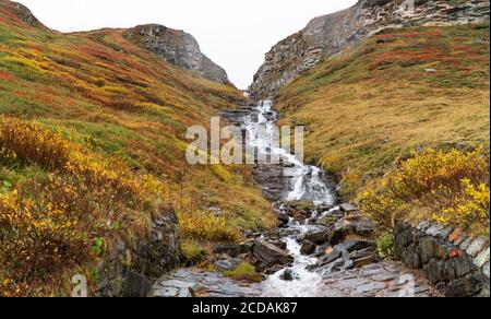 Small, clear stream cascading down the side of the mountain Stock Photo