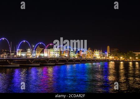 Night view of the Queen Emma Bridge, a swinging pontoon bridge originally built in1888 across St. Anna Bay, connecting Otrabanda and Punda in Willemst Stock Photo