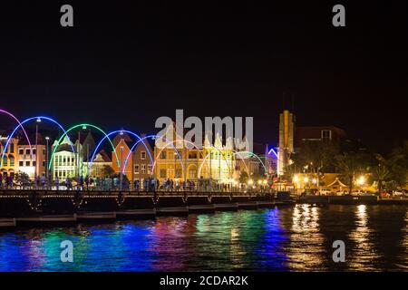 Night view of the Queen Emma Bridge, a swinging pontoon bridge originally built in1888 across St. Anna Bay, connecting Otrabanda and Punda in Willemst Stock Photo