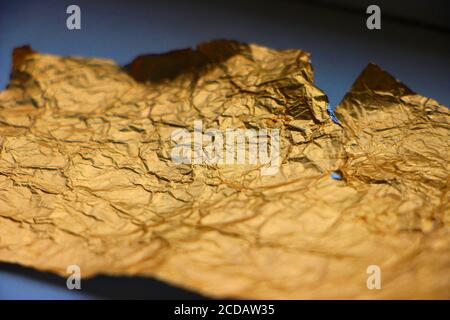 Crumpled torn golden bronze foil texture background Stock Photo