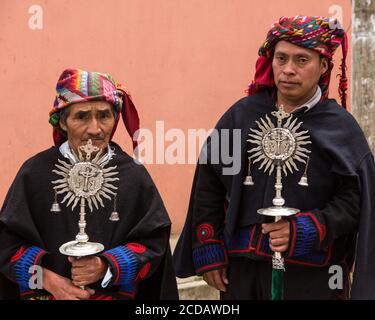 Two cofrades or officals in a cofradia or religious society with their silver staffs of office and elaborate panuelo headscarves in Chichicastenango, Stock Photo