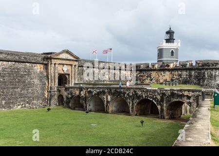 The entrance over the dry moat to the Castillo San Felipe del Morro.  The El Morro LIghthouse was built in 1908.  Old San Juan, Puerto Rico.  San Juan Stock Photo