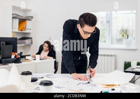 An engineer supervisor working on the drawings in the office. Stock Photo