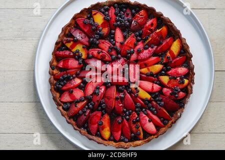 Homemade tart with fresh plumcots and blueberries Stock Photo