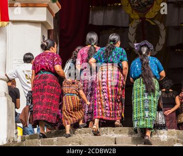 An older Cakchiquel Mayan woman in traditional dress examines the