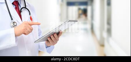 A side view of a male doctor using a tablet at the hospital. Stock Photo
