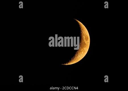 Orange colored waxing crescent moon; the orange glow is the result of the smoke coming from the wildfires burning all aver the San Francisco Bay Area, Stock Photo