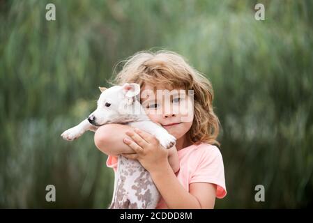 Hug friends. Happy child and dog hugs her with tenderness smiling. Stock Photo