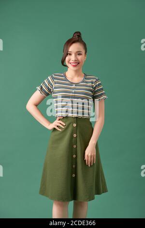 Casually dressed young woman over green background Stock Photo