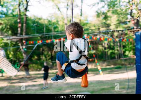 Happy kid enjoying activity in a climbing adventure park. Stock Photo