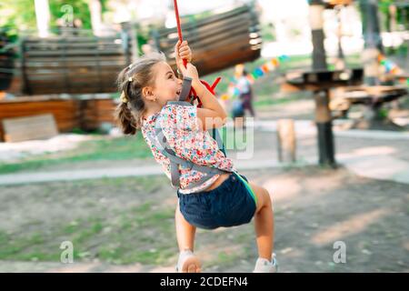 Happy kid enjoying activity in a climbing adventure park. Stock Photo