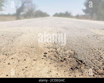 Dangerous road, potholes in the asphalt on the road and fog Stock Photo