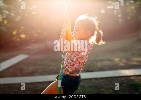 Happy kid enjoying activity in a climbing adventure park. Stock Photo