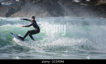 A panoramic image of a young surfer riding a wave at Fistral in Newquay in Cornwall. Stock Photo