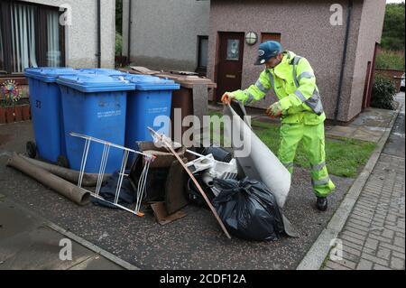 A worker cleaning up after flooding in Pyothall Court in Broxburn, West Lothian. Stock Photo