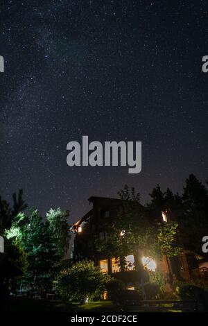 Wooden cottage with blue starry sky at night Stock Photo - Alamy